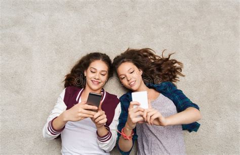 Adolescenti Felici Che Si Trovano Sul Pavimento Con Lo Smartphone Immagine Stock Immagine Di