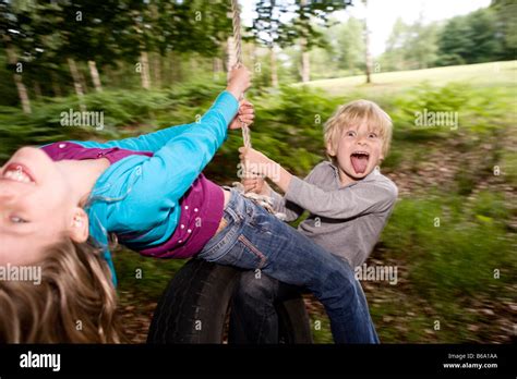Boy And Girl On Tire Swing Stock Photo Alamy