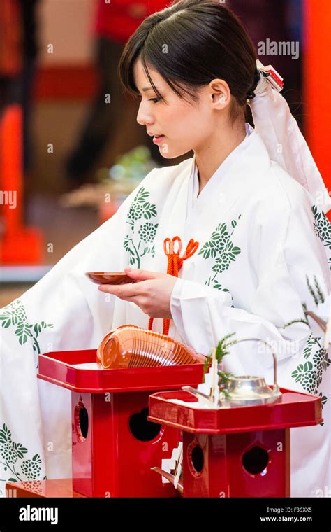 Shinto Shrine Maiden Miko Handing Out Ts Offerings To Paying