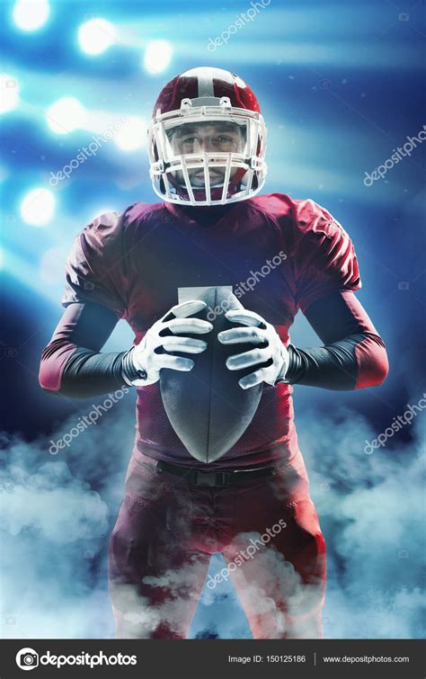 American Football Player Posing With Ball On Stadium Background Stock