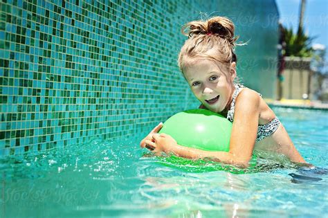 Girl In Pool With Green Ball By Gillian Vann Swimming Pool Stocksy