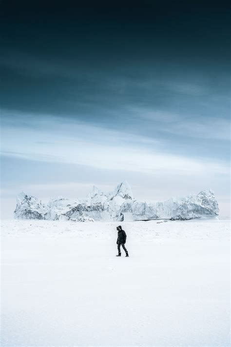 Download Premium Image Of Man Walking Through The Snow At Ilulissat