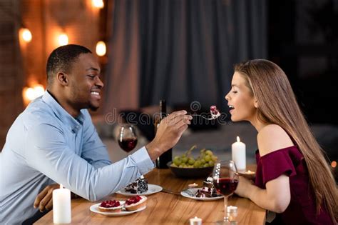 Happy Interracial Couple Having Romantic Moments At Dinner In