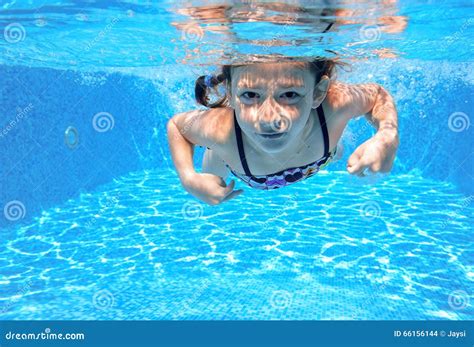 Ребенок плавает в бассейне подводном счастливая активная девушка имеет
