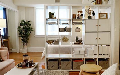 A White Kallax Bookshelf With Boxes And Doors Is Used As A Room Divider