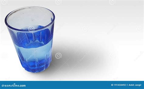A Half Filled Blue Glass With Water Isolated In White Stock Photo
