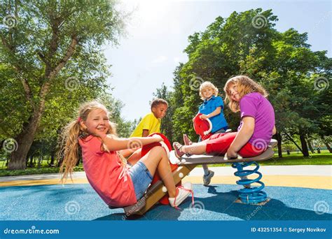 Children Sit On Playground Carousel With Springs Stock Photo Image