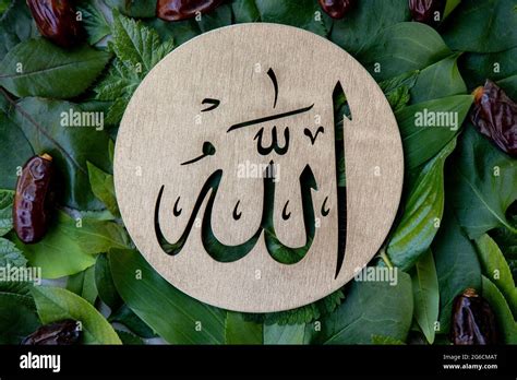 Name Of Allah In Arabic On Gold Wood Green Leaves And Dates Fruit