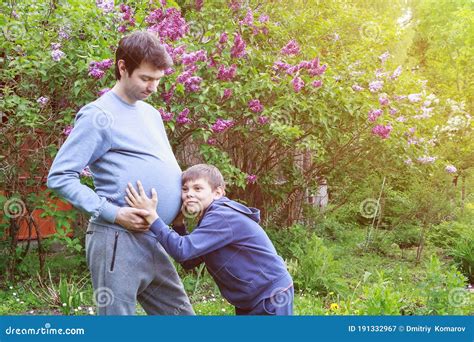 Pregnant Father With His Son Listening To The Baby In The Belly Of His