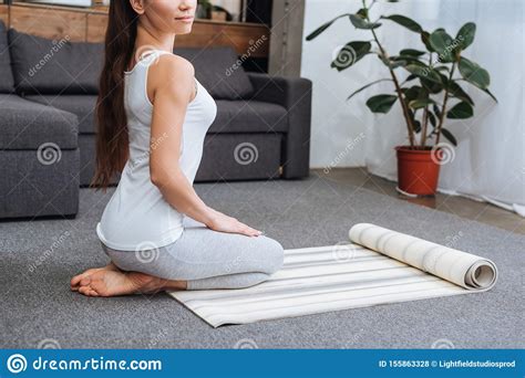Cropped View Of Woman Sitting On Fitness Mat And Practicing Hero Pose