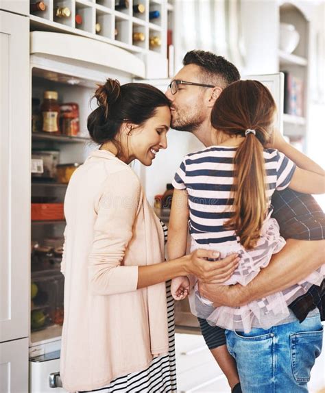 Hes Such A Loving Husband A Husband Lovingly Kissing His Pregnant Wife In The Kitchen While