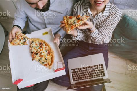 Young Hipster Male Female Couple Home Eating Pizza With Laptop Stock