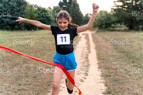 Cute Girl Runner Crossing Finish Line In A Race Competition In Nature