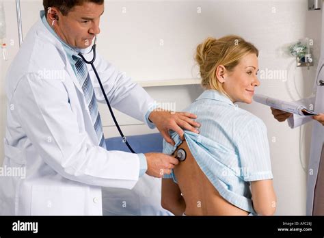 Doctor auscultating female patient Stock Photo - Alamy