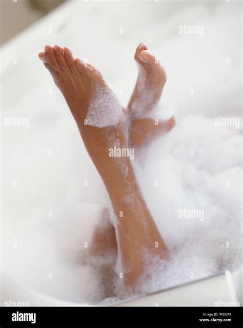 Woman S Lower Legs And Feet Sticking Out Of Bathtub Covered In Foam Stock Photo Alamy