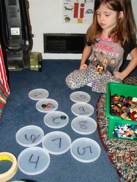 Counting Buttons Onto Numbered Lids At Childrens Wellness Preschool