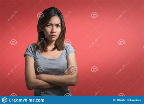 emotion concept portrait of angry cute asian woman standing posing with crossed arms looking at