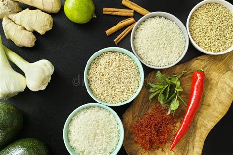 Bowls With Different Types Of Rice Vegetables And Spices Stock Photo