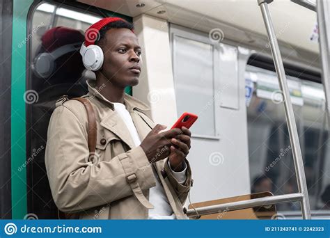Pensive Black Man In Subway Train Thinking Using Cellphone Listens To