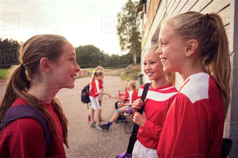 Girls Talking Against Friends By Wall Stock Photo Dissolve