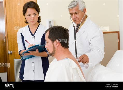 Doctor And Nurse Examining Patient In Hospital Room Stock Photo Alamy
