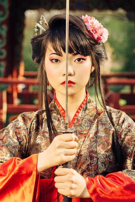 beautiful korean woman or geisha in kimono holding samurai sword near face beautiful geisha