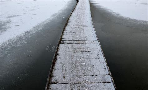 Wooden Pedestrian Bridge Over Frozen Snowy River Pond Lake No Railing