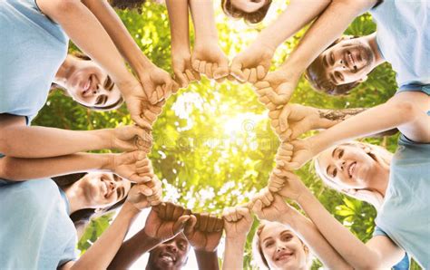 Team Of Happy Volunteers Fist Bump Together In Park Stock Photo Image