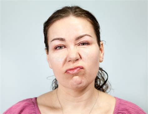 Indifferent Lazy Facial Expression In An Adult Woman Portrait On Grey