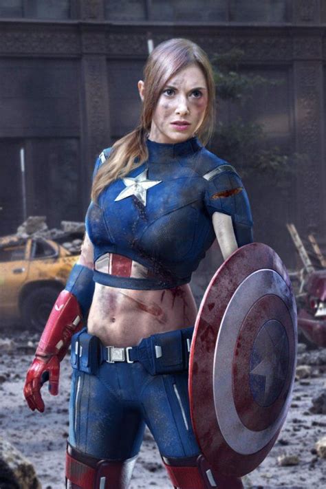 A Woman Dressed As Captain America Standing In The Mud With A Shield On