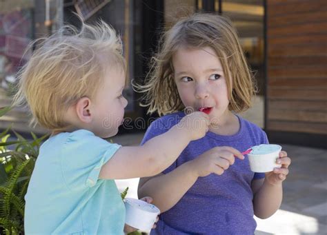Two Young Children Sharing Ice Cream Outside Stock Photo Image Of