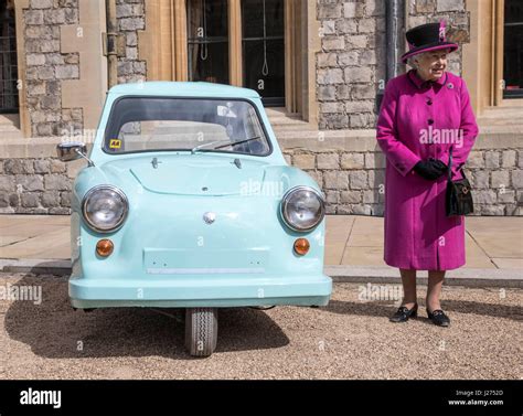 Queen Elizabeth Ii Stands Next To A Classic Invacar Invalid Carriage