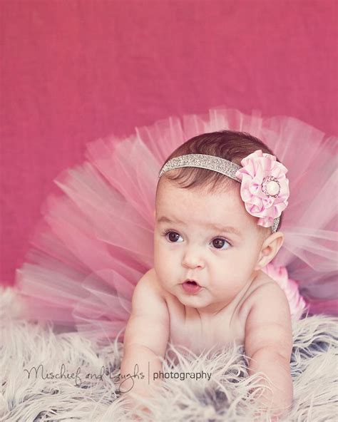 A Baby Girl Wearing A Pink Tutu And Headband