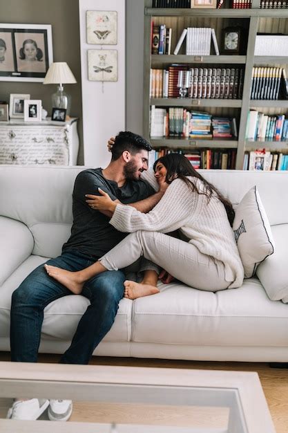 Dos jóvenes pareja sentada en el sofá haciendo el amor en la casa moderna Foto Gratis
