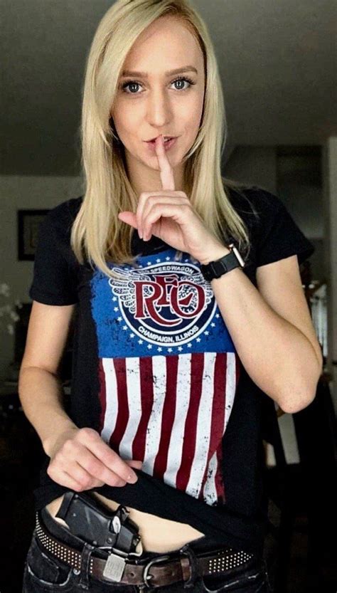 a woman is posing for the camera with her finger in her mouth and an american flag t shirt on