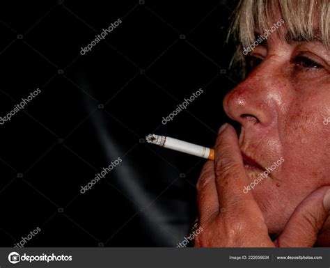 Mature Woman Smoking Cigarette — Stock Photo © Anuskiserrano 222656634