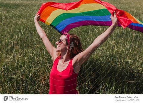 Woman Holding The Gay Rainbow Flag Over Blue Sky A Royalty Free Stock Photo From Photocase