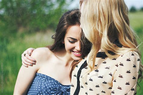 two female friends hugging and laughing outdoors by jovana rikalo stocksy united