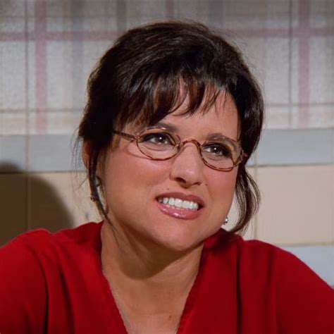A Woman With Glasses Is Smiling For The Camera While Wearing A Red