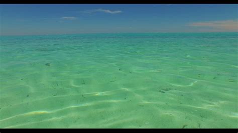 Crystal Clear Emerald Green Water Under A Bright Blue Summer Sky In