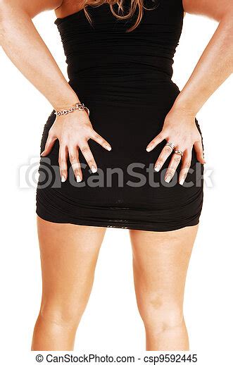 Woman Holding Her Butt A Young Woman In A Black Dress Standing And