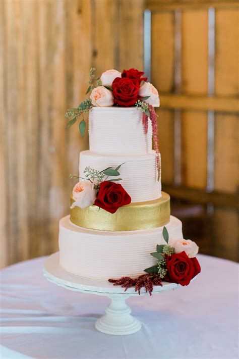 Inside, the cake features flavors of chocolate, salted caramel, and raspberry cream. Romantic White Wedding Cake With Burgundy Flowers