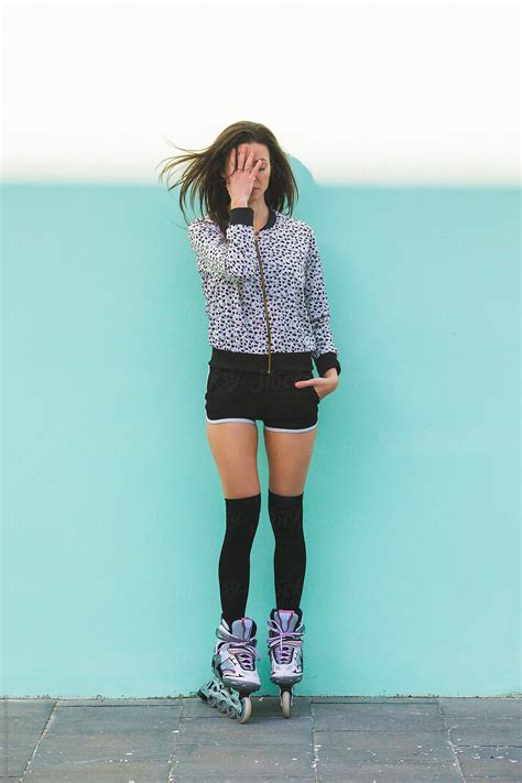 Young Roller Girl With Flying Hair Hiding Her Face With Hand In Front