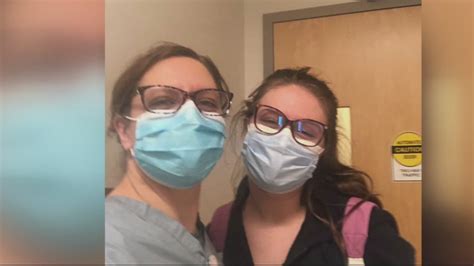 Mother And Daughter Nurses Lean On One Another Helping Patients With