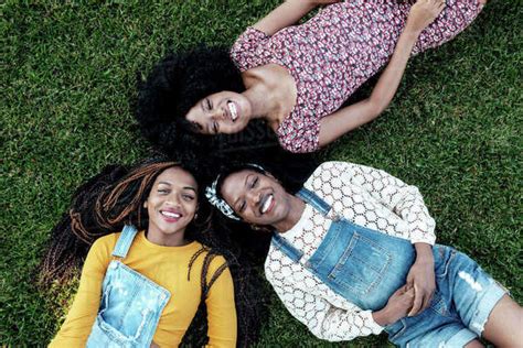 Top View Of Delighted Multiracial Female Friends Relaxing On Green Lawn