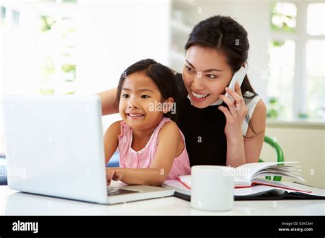 Busy Mother Working From Home With Daughter Stock Photo Alamy