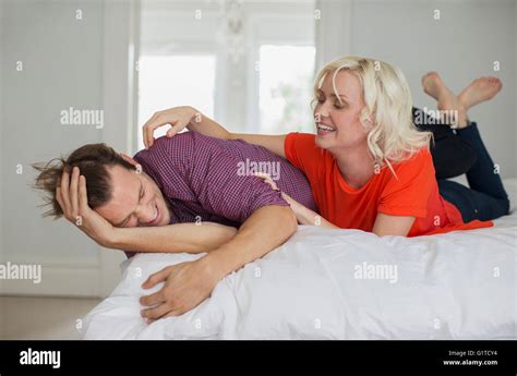 Verspielte Frau Kitzeln Mann Auf Bett Stockfotografie Alamy