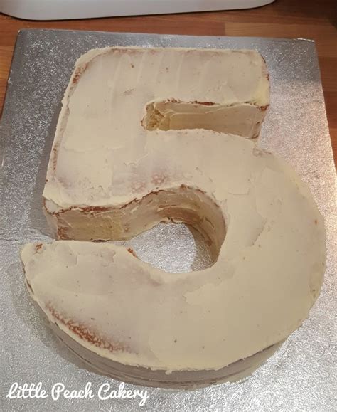 A Cake That Is Shaped Like The Number Five With Frosting On Its Side