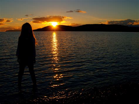 Girl Staring Across The Lake Into The Sunset Image Free Stock Photo
