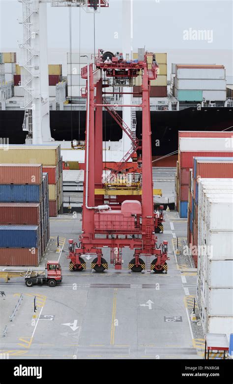 Cargo Containers Truck And A Crane In Storage Area Of Freight Port